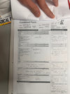 A hand holding a printed medical form titled "Combined Form," with handwritten notes visible, photographed from above on a flat surface.